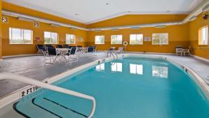 a large swimming pool with chairs and a table at Best Western New Baltimore Inn in West Coxsackie