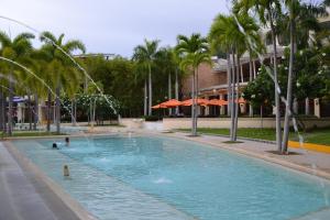 een groot zwembad met palmbomen voor een gebouw bij Apartment in Pico De Loro in Nasugbu