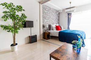 Un dormitorio con una cama y una mesa en una habitación. en FDS En Osaka, en Osaka