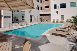 a swimming pool with chaise lounge chairs and a building at Hyatt House Irvine/John Wayne Airport in Irvine
