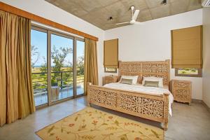 a bedroom with a bed and a large window at Manna Villa in Mahabalipuram