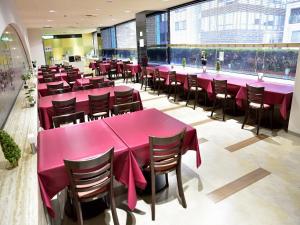 un comedor con mesas y sillas rosas en Hotel Fukuoka Garden Palace, en Fukuoka