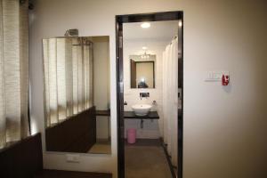 a bathroom with a sink and a mirror at Hotel Girnar in Aurangabad