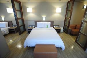 Kindness Hotel - Hanshen tesisinde bir odada yatak veya yataklar