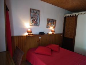 um quarto com uma cama com lençóis vermelhos e 2 candeeiros em Le Cardinal des Grands Bleus em Saint-Leu