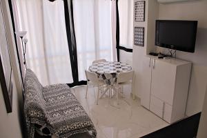 sala de estar con mesa, sillas y TV en Apartamento Horizonte, en Calpe