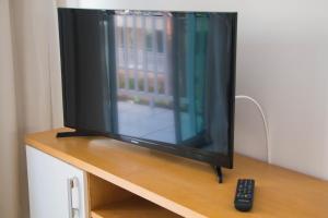 un televisor sentado en una mesa con mando a distancia en Blue Beach Temporada, en Aquiraz