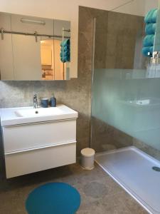 a bathroom with a white sink and a shower at Alpenaquarium Grüblsee - FEWO Monika in Vordernberg