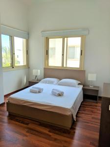 a bedroom with a large bed with two towels on it at ANTHORINA VILLA 9 in Protaras