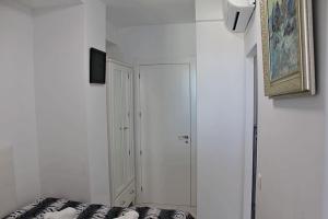 Habitación blanca con cama y armario en Apartamento Horizonte, en Calpe