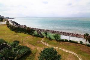 a long pier with people sitting on it next to the ocean at Penghu Luna Sea Homestay in Magong