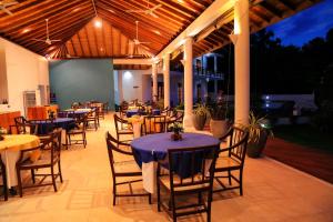 a dining area with tables and chairs and lights at Waterside Bentota in Bentota