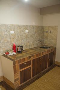 a kitchen with a sink and a stone wall at The Barfung Retreat in Gangtok