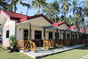 a resort with a row of tables and palm trees at Aloha Seaside Resort in Siquijor