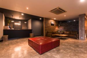 un vestíbulo con un banco en el medio de una habitación en Hotel cooju Fukui, en Sakai