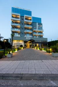 a building with a parking lot in front of it at Agrinio Imperial Hotel in Agrinio