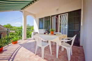 eine Terrasse mit Tisch und Stühlen auf einem Balkon in der Unterkunft Holiday Home Vinac in Dazlina