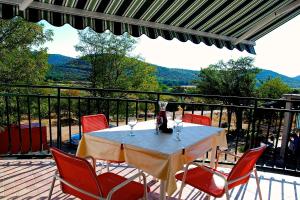 einen Tisch mit Stühlen und Weingläsern auf dem Balkon in der Unterkunft Holiday Home Vinac in Dazlina