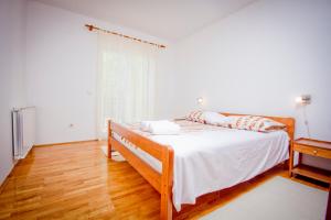 ein Schlafzimmer mit einem Bett mit weißen Laken und einem Fenster in der Unterkunft Holiday Home Vinac in Dazlina + 18 Fotos