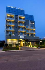 a hotel building with a sign on top of it at Agrinio Imperial Hotel in Agrinion