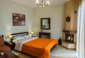 a bedroom with a bed and a fireplace at Chrysandra in Karpenisi