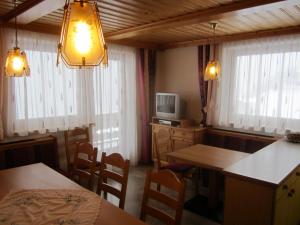een kamer met 2 tafels, een tv en een aantal ramen bij Haus Ladner - Josef und Marianne in Kappl