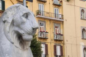 uma estátua de um leão em frente a um edifício em Maison Plebiscito em Nápoles
