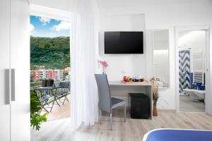 a white living room with a table and a balcony at Sirocco Suites in Sant'Agnello