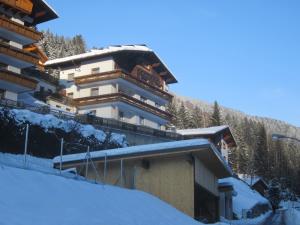 ein Gebäude auf einem schneebedeckten Hügel mit einer Skipiste in der Unterkunft Haus Ladner - Josef und Marianne in Kappl