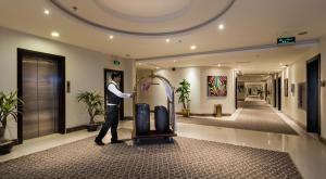 a man standing in a lobby with a suitcase at Myan Al Urubah Hotel in Riyadh