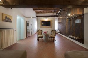 a room with chairs and a table and a tv at Alkimia Apartments in Ferrara