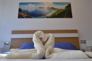 a bed with a pair of towels making a heart at oasis de sueno 2 in Alicante