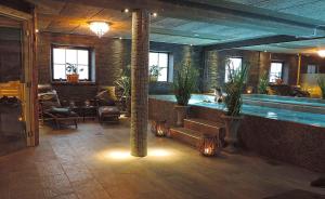 a large indoor swimming pool with potted plants in a room at Lanthotell Lögnäs Gård in Laholm