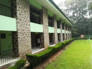 a large building with a grass yard in front of it at Periyar House in Thekkady