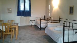 1 Schlafzimmer mit 2 Betten, einem Tisch und einem Esszimmer in der Unterkunft Agriturismo San Bruno in San Colombano al Lambro