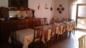 una sala da pranzo con tavoli e sedie e una cucina di Agriturismo San Bruno a San Colombano al Lambro