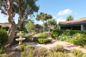 a garden with a fountain and a tree at Résidence Blue Marine in Porto-Vecchio