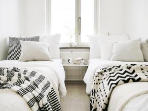 two beds with black and white sheets in a bedroom at Roost Kristian in Helsinki
