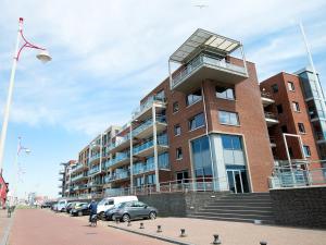 斯海弗寧恩的住宿－BizStay Harbour I Scheveningen Apartments，一座大型建筑,前面有汽车停放