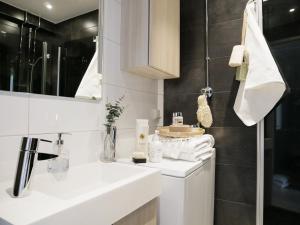 a white bathroom with a sink and a mirror at Roost Kristian in Helsinki