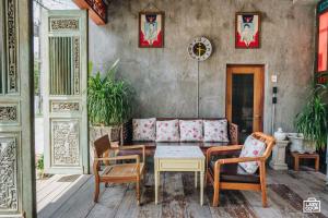 a living room with a couch and a table and chairs at House Of Passion Amphawa in Amphawa