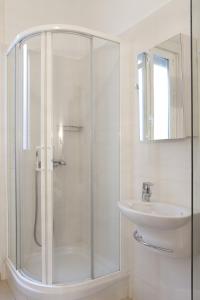 baño blanco con ducha y lavamanos en AVA Rooms, en Madrid