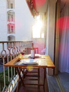 uma mesa com um copo de vinho na varanda em Le Sunlight, quiet and cosy with terrace! em Nice