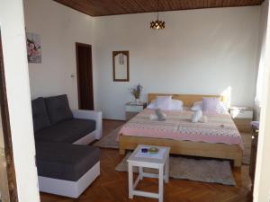 een slaapkamer met een groot bed en een bank bij Apartment in Starigrad-Paklenica 34070 in Starigrad-Paklenica