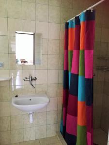 a bathroom with a colorful shower curtain and a sink at Promenád apartmány in Veľký Meder