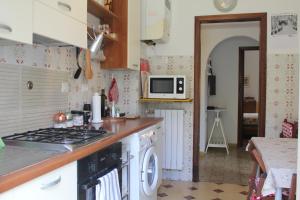 uma cozinha com um fogão e uma máquina de lavar e secar roupa em Appartamento Liberazione - 5 Terre Region em Moneglia