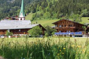 a large building with a church and a grass field at Moahof in Alpbach
