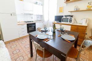 a kitchen with a table with chairs and a microwave at Apartment In The Heart Of Sanremo in Sanremo
