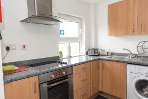 a kitchen with a sink and a stove top oven at Very Central Location- Parking-4 Beds-2 Bedrooms in Belfast