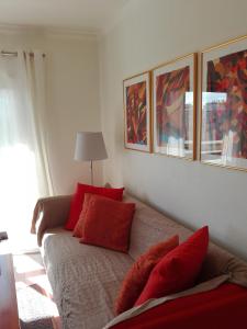 a living room with a couch with red pillows at Apartamento Turf in Alvor